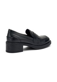 Mocasines de cuero negro con un bajo tacón bloque, punta redonda y detalles de costura. El diseño presenta un estilo fácil de poner y una textura suave.