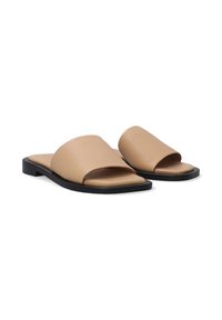 Béžové kožené sandály na klínku s širokým páskem, otevřenou špičkou a plochou černou podrážkou. Hladký povrch, minimalistický styl, obdélníkový tvar.