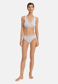 Světlý šedý prádlo vyrobené z měkké tkaniny. Braletka má krajkový okraj a výstřih do V. Vysoké kalhotky mají odpovídající krajkový detail.