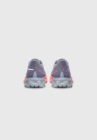 Scarpe sportive con una tomaia in rete viola, intersuola grigia e suola rosa. Il design include motivi testurizzati e accenti riflettenti.