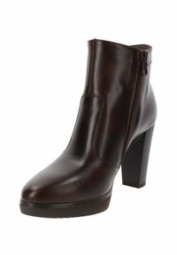 Bottine en cuir marron avec une finition lisse, une fermeture éclair sur le côté et un talon bloc haut. Bout arrondi et plateforme légèrement surélevée.