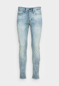 Jeans skinny de mezclilla azul claro con un lavado descolorido, cinco bolsillos y cierre de botón. Presenta detalles cosidos y puños rematados.