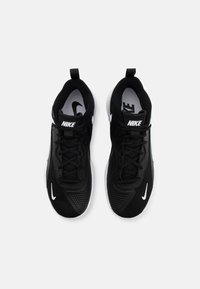 Scarpe da atletica nere con tomaia in rete, lacci piatti e logo Nike bianco. Presentano una texture perforata e una suola bianca ammortizzata.