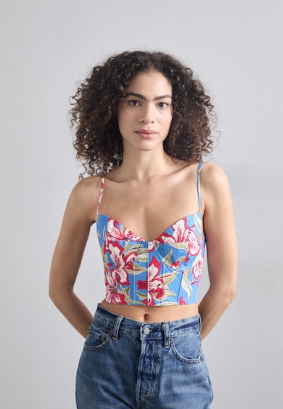 Top corto colorido en azul con un patrón floral en rosa y verde. Presenta un escote corazón y tirantes finos, hecho de tela estampada.