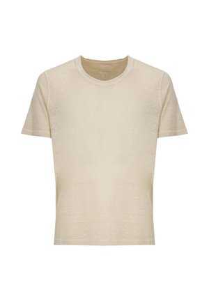 Giovane uomo con camicia beige chiaro, camicia nera a maniche lunghe con bottoni, pantaloncini neri e scarpe beige slip-on, in piedi e guarda verso destra.