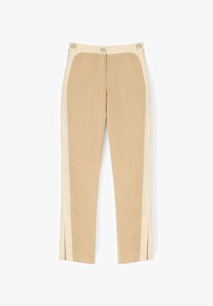 Pantalon beige fuselé avec des panneaux latéraux plus clairs, boutons avant à la taille et fentes latérales à l'ourlet, posé à plat sur un fond blanc.