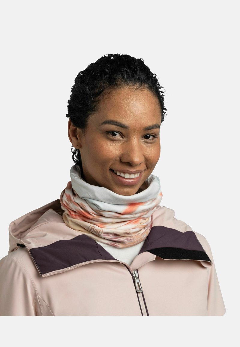 Multicolor neck gaiter with swirls of orange and white, crafted from soft, elastic fabric. Worn under a light pink jacket with dark accents.