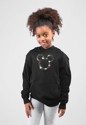 Svart hoodie med en blommig Mickey Mouse-logotyp, med en framficka. I kombination med grå leggings prydda med färgglada prickar.