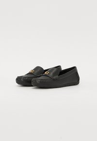 Mustad musta nahast loafertid tekstureeritud ülemise osa, dekoratiivne õmblus ja kuldse tooni detail esiosas. Sile ja paindlik tald.