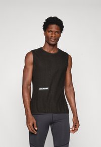 Top negru fără mâneci, dedicat performanței, dintr-un material texturat, cu decolteu rotund și logo-ul alb "Mammut" pe față. Purtați cu pantaloni întunecați.