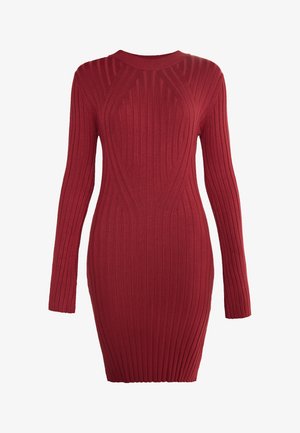 Rdeča pletena obleka z dolgimi rokavi, okroglim izrezom in oprijetim silhueto. Ima dvignjene vertikalne črte in strukturo površine.