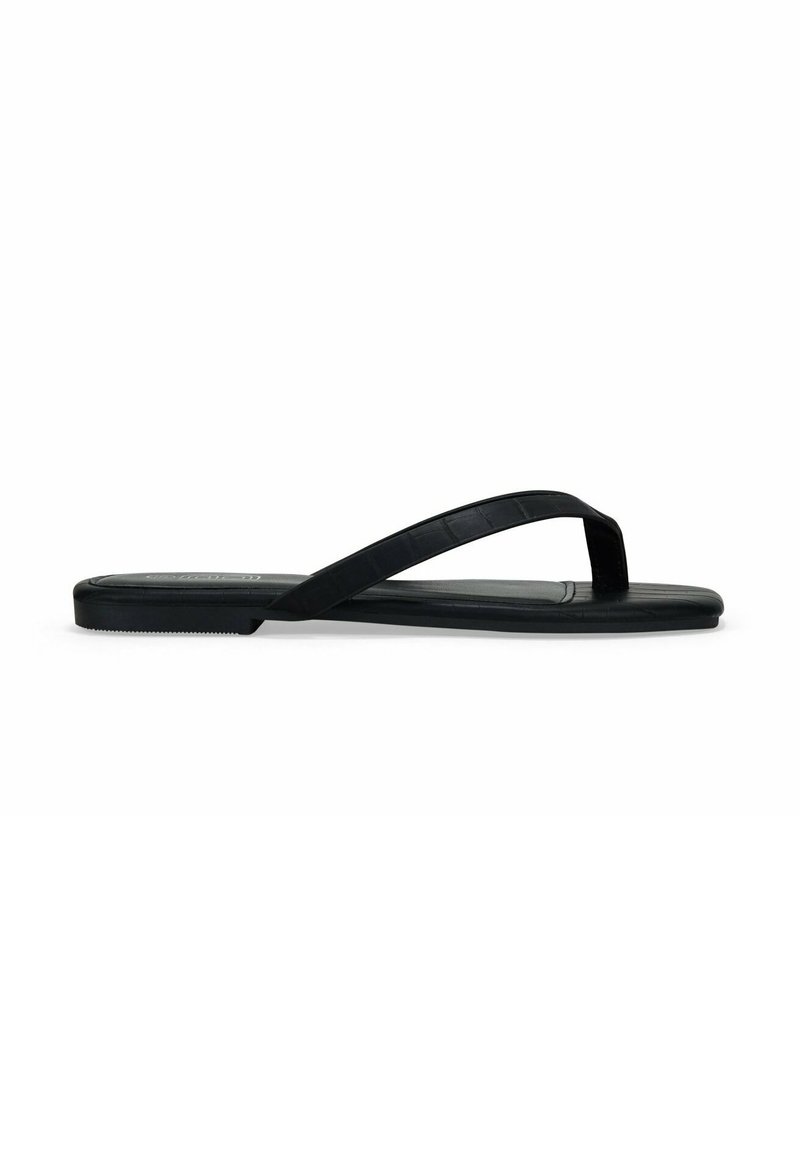 Chancla negra de goma, con suela plana, tiras delgadas y un patrón texturizado en la plantilla. Diseño minimalista, vista de perfil lateral.