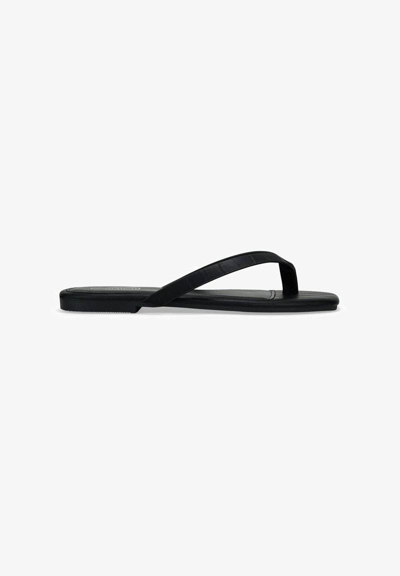 Chancla negra de goma, con suela plana, tiras delgadas y un patrón texturizado en la plantilla. Diseño minimalista, vista de perfil lateral.