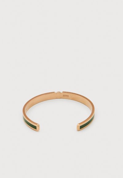 Βραχιόλι ανοιχτό με επίχρυσο τόνο, ενθέσεις από πράσινο σμάλτο και χαραγμένο μοτίβο ελληνικού κλειδιού, με το λογότυπο Versace στο εσωτερικό.
