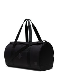 Sac de sport noir en tissu texturé avec une forme arrondie. Dispose de deux poignées, d'une sangle réglable et d'un logo discret.