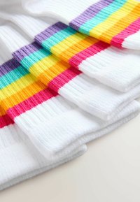 Calcetines de algodón de rayas coloridas con base blanca y bandas horizontales en rosa, naranja, amarillo, verde y morado. Textura suave y acanalada.