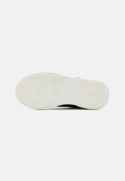 Semelle de sneaker noire avec une base en caoutchouc blanc. Présente un motif de gumtree en zigzag pour l'adhérence et une construction en matériau durable. Marquage de taille visible.