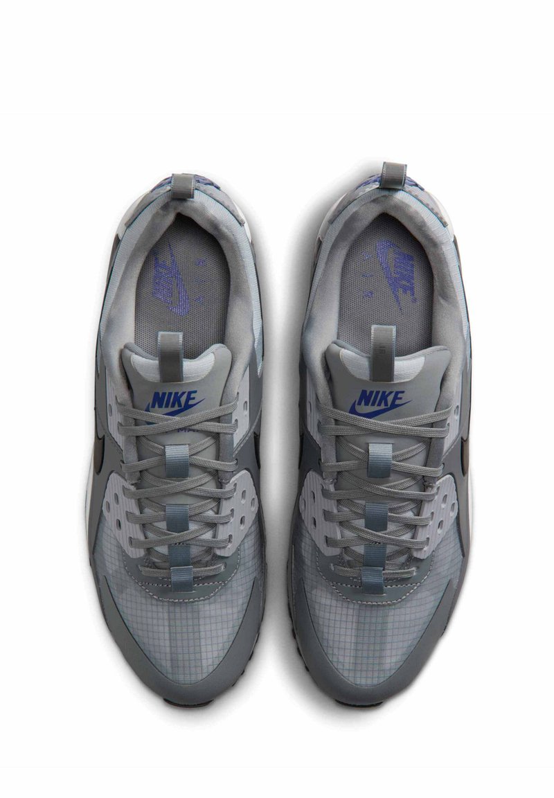 Paire de baskets Nike grises avec logo bleu, empeigne en mesh et synthétique, lacets noués, vues de dessus sur fond blanc.