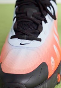 Pantof cu un design în gradient de la albastru deschis la coral, superior din plasă texturată, șireturi negre și talpă din cauciuc cu accente distincte.