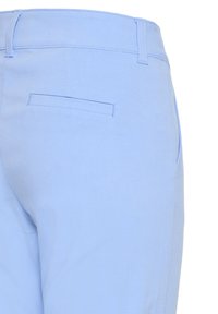 Svetlomodré nohavice zobrazené zozadu s jedným lemovaným vreckom a viditeľnými očkami na opasok na páse.