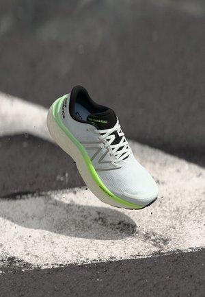 Sapatilha de corrida branca com detalhes em preto e sola verde. Pupper texturizada com sistema de atacadores. Logótipo "Fresh Foam" visível na lateral.