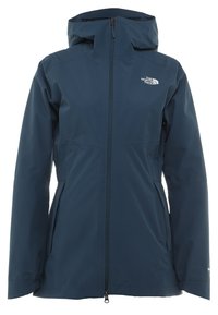 Veste imperméable bleu marine avec capuche, fermeture éclair intégrale à l'avant, poches latérales et logo The North Face sur la poitrine.