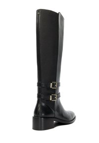 Botte noire hauteur genou en cuir lisse et en tissu, dotée de deux sangles réglables avec des boucles en or et d'un talon bloc solide.