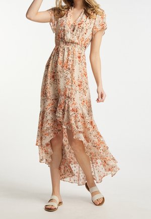 Robe maxi florale beige avec des motifs orange et verts. Elle présente un décolleté en V, des manches courtes et un ourlet asymétrique avec des bords volants.