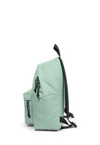Mátově zelený batoh s přední kapsou, černými zipy, horním držadlem a polstrovanými černými ramenními popruhy, zobrazený v bočním profilu.