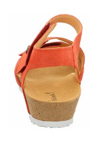 Sandal in suede arancione con base in sughero, vista posteriore. Dotata di una fascia regolabile e una soletta testurizzata. La suola bianca aggiunge contrasto.