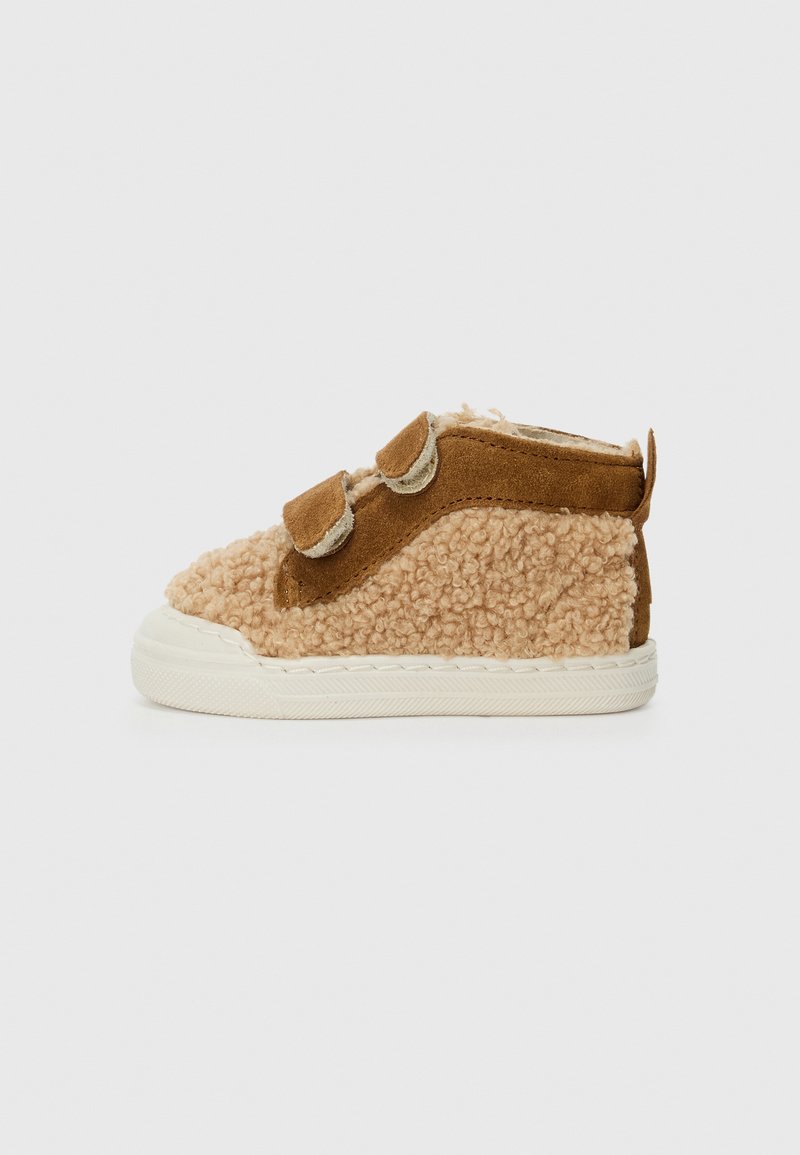 Brune og beige småbarnsko med en teksturert fluffy overdel, suède-detaljer, to borrelåsbånd og en hvit gummisåle.