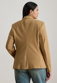 Camelfarget blazer laget av teksturert stoff, med skreddersydd passform, hakkede slag og gullfargede knappedetaljer på ermene.
