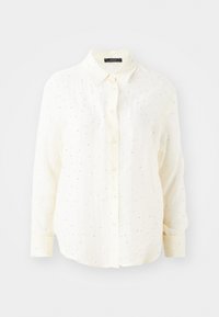 Camisa de manga larga abotonada en color crema con cuello abotonado, que presenta una ligera textura y acentos de pequeños puntos plateados.