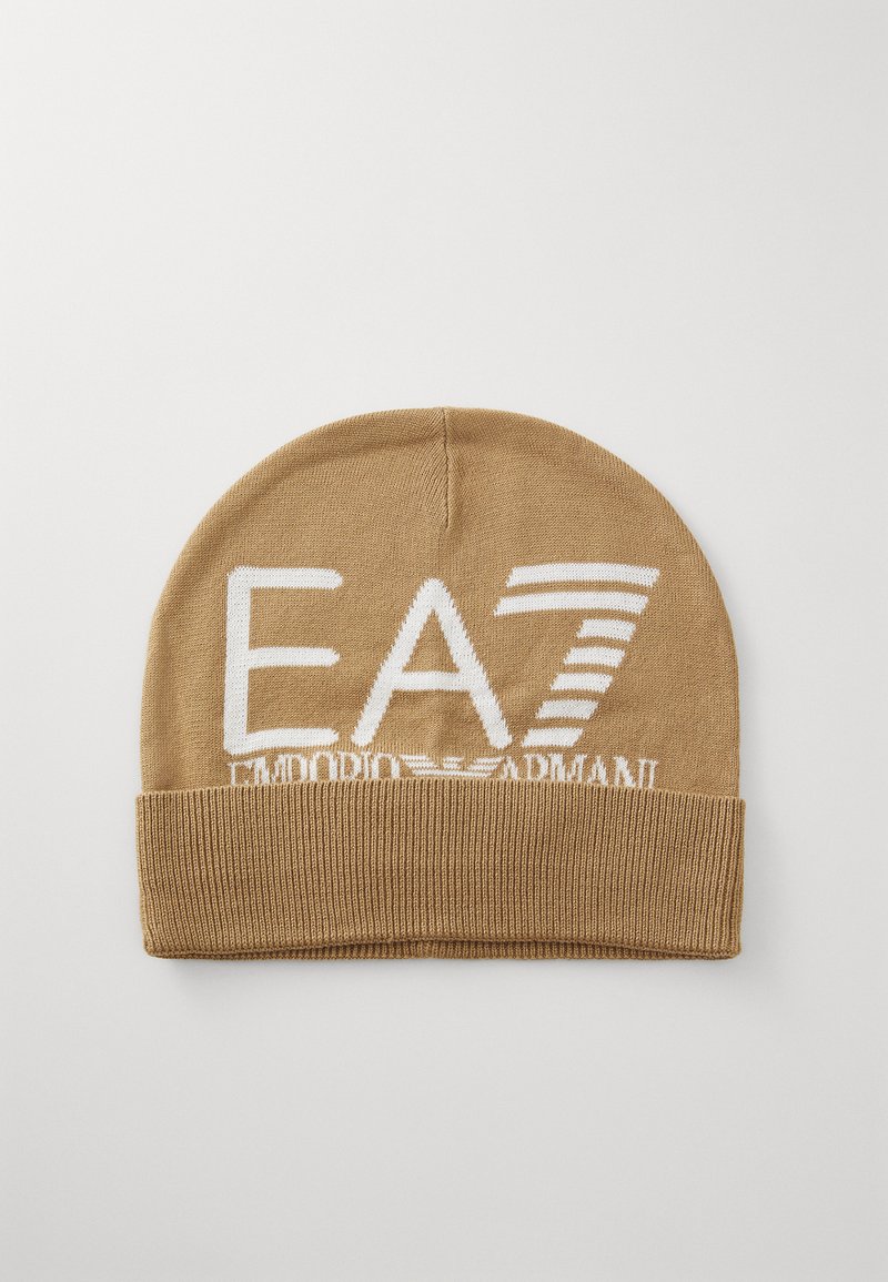 Bézs kötött sapka, hajtott mandzsettával. Az elején fehér színnel szerepel az "EA7" és az "Emporio Armani" felirat, a szöveg felett vízszintes csíkokkal.