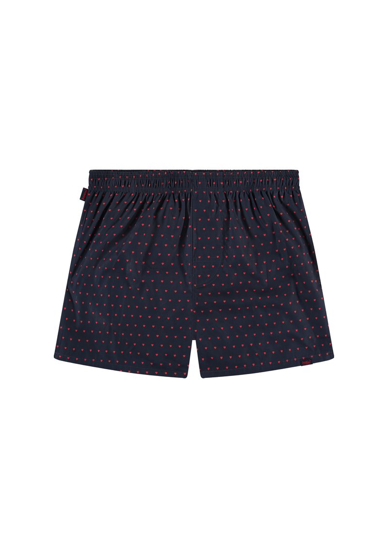 Boxers bleu marine avec un motif de cœurs rouges, taille élastique, coupe ample, et une petite étiquette de marque sur le côté. Texture de tissu lisse.