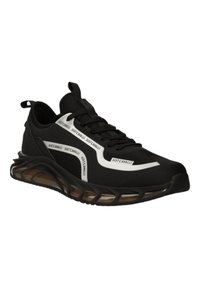 Chaussure de sport noire avec tige en maille, semelle rembourrée et accents blancs. Présente une marque le long du côté et une semelle en caoutchouc texturée.