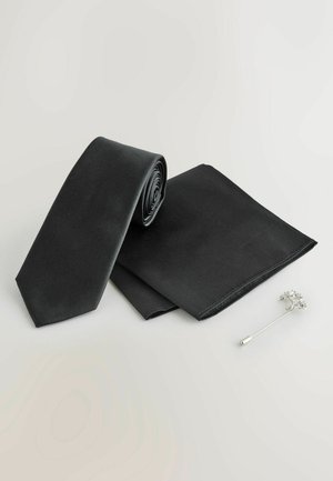 Must mustreid siidist lips, volditud, koos sobiva taskurätikuga. Omab läikivat tekstuuri ja teravat tippu. Sisaldab hõbedast lillemotivi krae pinsakut.