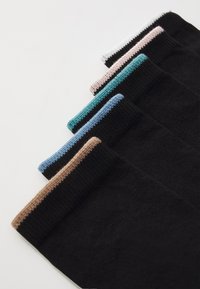 Schwarze Socken mit kontrastierenden farbigen Bündchen: beige, teal, hellblau, rosa und weiß. Die Textur scheint weich zu sein; das Strickmuster ist an den Bündchen sichtbar.