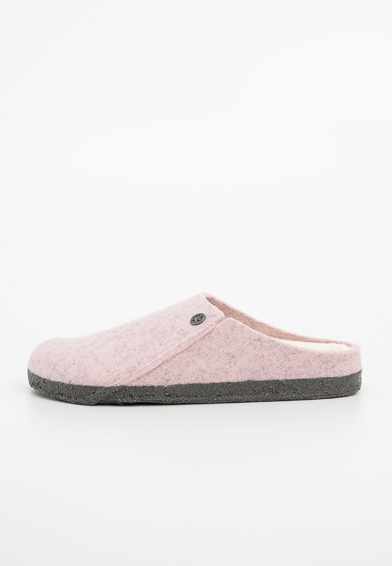 Pink felt slipper with a rounded shape, gray rubber sole, and small logo accent. The interior features a soft, fuzzy lining.