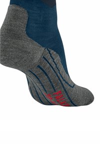 Calzino sportivo blu e grigio con aree di supporto testurizzate, indossato su un piede inclinato di lato, con testo rosso vicino alle dita.