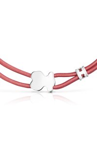 Czerwony podwójny sznurkowy bransoletka z błyszczącym srebrnym charms'em w kształcie misia oraz srebrnym zapięciem z małymi wycięciami w kształcie misia.