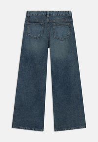 Wide-leg blue denim jeans with a mid-rise waistband, double back pockets, and a faded texture, showcasing a casual design.