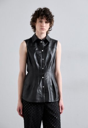 Top de couro preto sem mangas com um ajuste estruturado, apresentando uma gola pontuda e fecho frontal por botões, acentuado por costuras verticais.