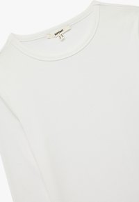 Hvid bomulds T-shirt med rund halsudskæring, korte ærmer og en glat, blød tekstur. Etiketten ved halsen siger "Kenton."