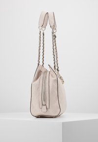 Rosa läderhandväska med präglat mönster, kedja och läderremmar samt dragkedjestängning. Rundade sidor med detaljerad sömnad.