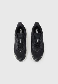 Schwarze Sportschuhe mit einem strukturierten Mesh-Obermaterial, gepolstertem Schaftrand und reflektierenden Akzenten. Verfügt über Schnürsenkel und eine gepolsterte weiße Zwischensohle.