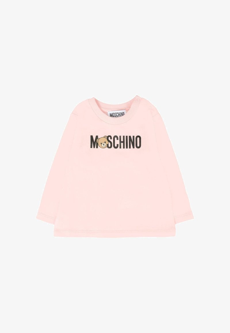 Chemise à manches longues rose en coton doux, avec un logo d'ours et le texte "MOSCHINO" en noir. Col et poignets côtelés.