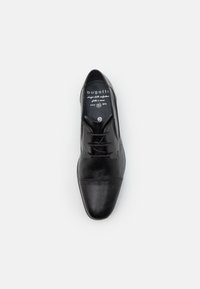 Black leather dress shoe with a pointed toe, lace-up design, and subtle stitching details. Features branding on the insole. Size 42.