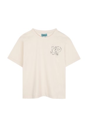 Beige katoenen T-shirt met korte mouwen, met een "KP"-ontwerp in zwarte stippen op de linker borst. Klassieke ronde hals, ontspannen pasvorm.