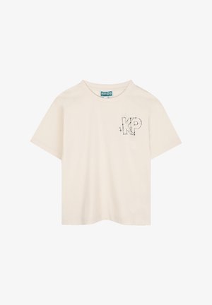 T-shirt en coton beige à manches courtes avec un design "KP" en points noirs sur la partie gauche de la poitrine. Col rond classique, coupe décontractée.